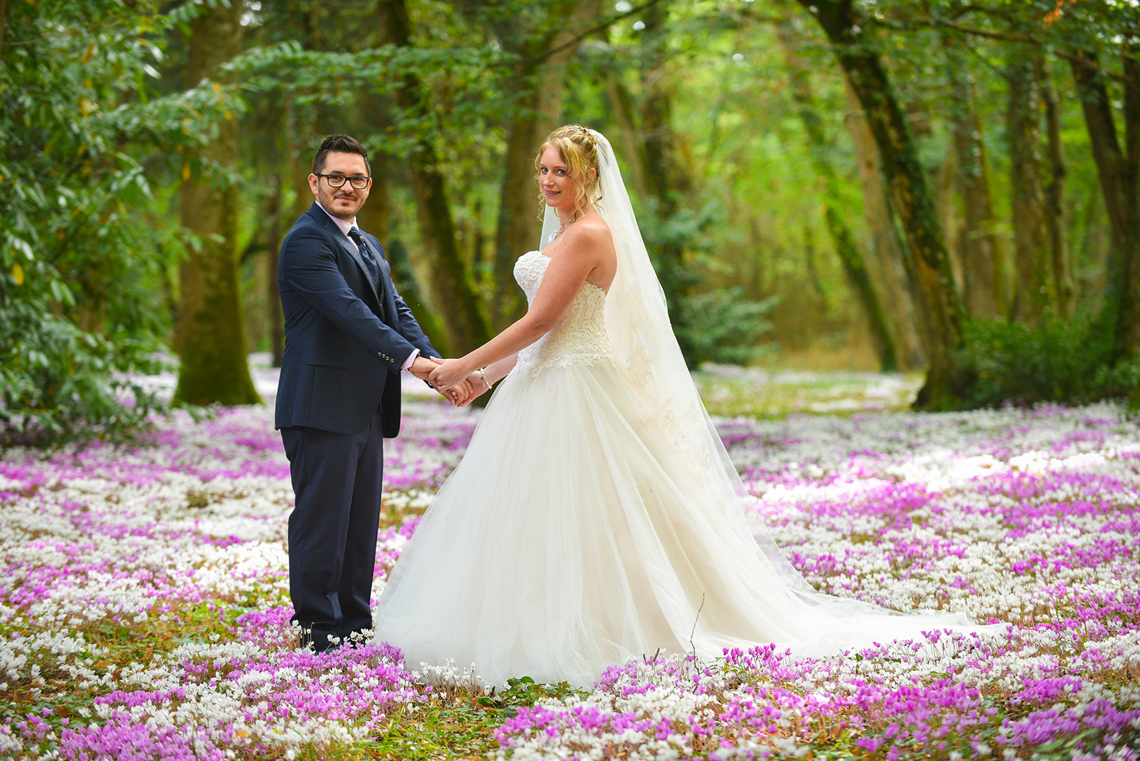 couple pose pour leur photo de mariage dans un bois